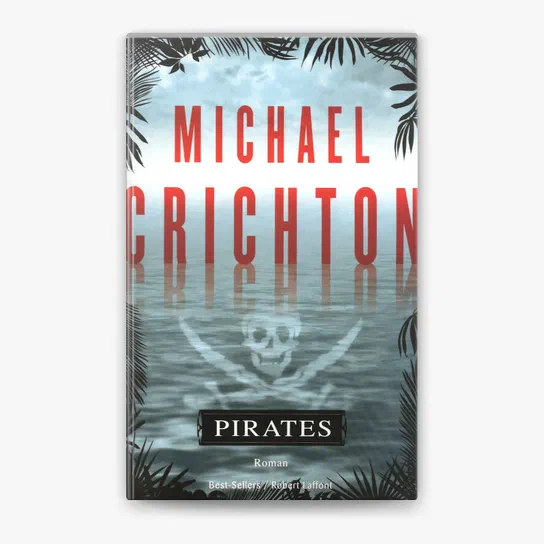 Couverture du livre Pirates de Michael Crichton avec un crâne et des os croisés reflétés dans l'eau.